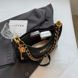 Sac à bandoulière matelassé noir avec chaîne dorée et élégant pendentif clé de luxe