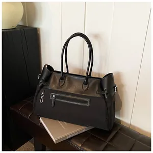 Detail view of large nylon tote bag with leather patchwork and front zipper pocket on bench
