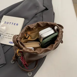 Brown leather drawstring bucket bag showing internal storage for daily essentials