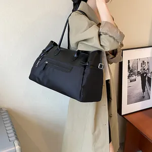 Large capacity black nylon tote bag with leather trim and front zip pocket for commuting