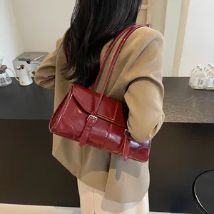 Borsa a spalla baguette vintage in pelle cerata rosso vino su un blazer kaki