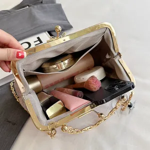 Pink shell handbag with golden kiss-lock closure and spacious interior compartment