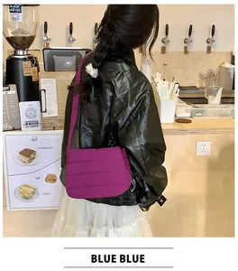 Detail of a purple quilted crossbody bag on a model wearing a leather jacket in a cafe