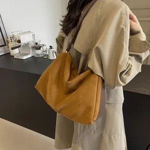Brown suede hobo bag with large capacity and leather strap in minimalist urban style