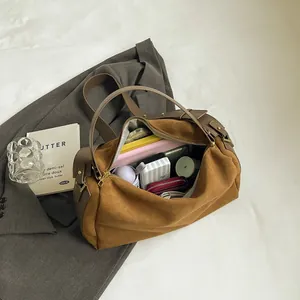 Brown suede Boston bag showing large capacity for umbrella and cosmetics with strap