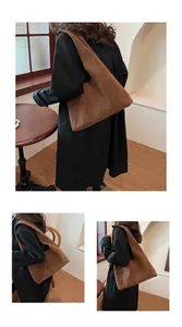 Detail of a large brown suede tote bag worn over a black coat for daily commuting style