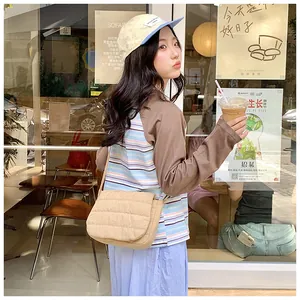 Chic beige quilted crossbody bag styled with a baseball cap for a casual daily look