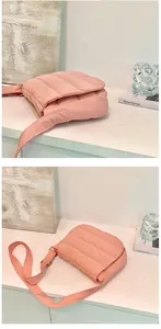 Detailed view of pink quilted crossbody cloud bag with soft fabric and matching wide strap