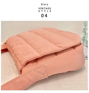 Close-up of pink quilted crossbody bag showing horizontal textured fabric and stitching detail