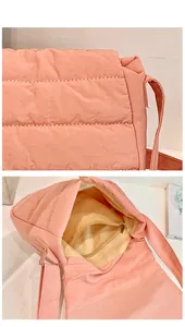 Detail view of pink quilted crossbody bag showing internal zipper pocket and lining