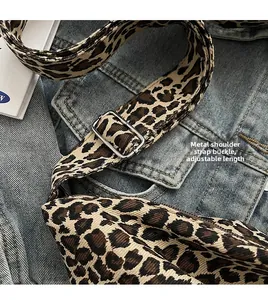 Detail of adjustable metal hardware buckle on leopard print leopard canvas bag strap