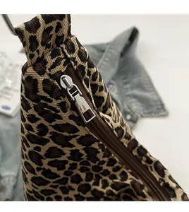 Detailed close-up of the smooth silver metal zipper on the leopard print canvas bag