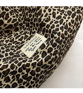 Detail shot of the durable leopard print canvas fabric and stitched brand woven label