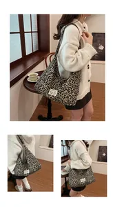 Detail of large leopard print canvas tote with shoulder strap and minimalist woven label