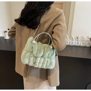 Détail du sac à main en peluche vert menthe avec chaîne argentée et perles blanches
