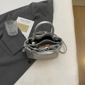Silberne gesteppte Beuteltasche mit Metallic-Finish, Tragegriff und Umhängeriemen