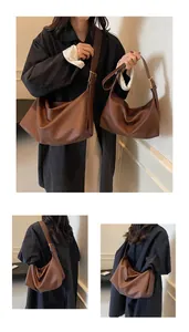 Détail de sacs demi-lune en cuir marron foncé en deux tailles avec boucles dorées