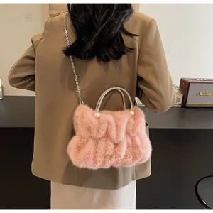 Sac à main rose en fausse fourrure avec plis, poignée en strass et détails en perles