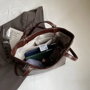Large brown leather tote bag with spacious interior and beige herringbone lining for daily use