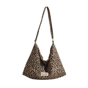 Detail of the high-capacity leopard print canvas tote bag featuring a white brand label