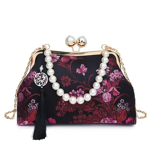 Bolso concha negro bordado con flores, cierre de perlas, asa y cadena dorada