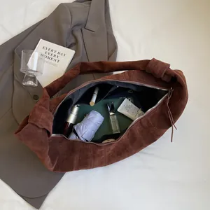 Large brown faux suede hobo bag with knotted strap and ample interior storage space
