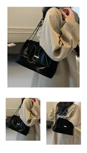 Macro view of high-gloss patent leather shoulder bag with silver logo and chain strap
