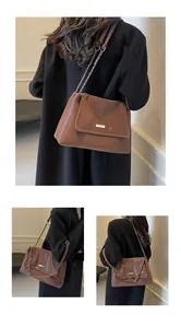Detail of glossy brown leather shoulder bag with silver logo plaque and chain strap