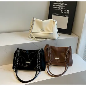 Detailed view of large shoulder bags with mixed leather and metal chain straps in three colors