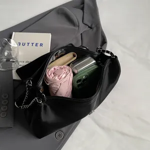 Black leather underarm bag showing large capacity for phone, umbrella and wallet