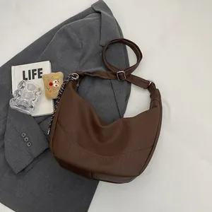 Detailed shot of brown hobo bag with pebble leather texture and adjustable shoulder strap