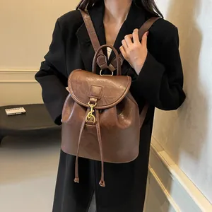 Detail of vintage dark brown backpack with bronze metal buckle and drawstring closure