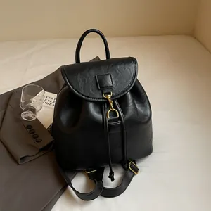 Detail of black faux leather backpack with gold clasp and urban lifestyle props