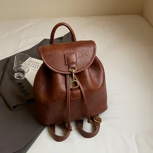 Top view of retro brown leather backpack with drawstring closure and metal buckle details