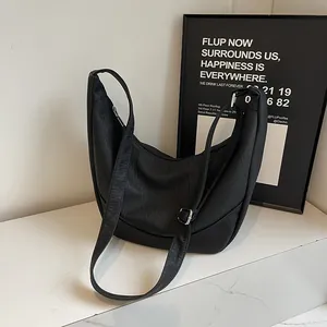 Close-up of black PU leather crescent shoulder bag with silver adjustable metal buckle