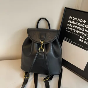 Close-up of black PU leather backpack featuring lychee texture and gold metal buckle