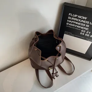 Detailed top view of dark brown PU leather bucket backpack with drawstring closure