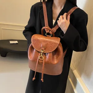 Retro brown PU leather backpack with gold buckle and drawstring in minimalist style