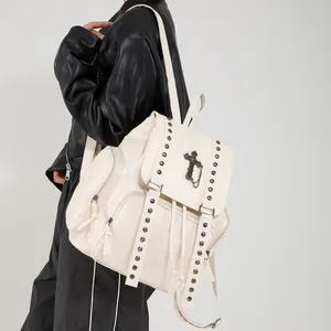 Chic cream white backpack with silver studs and cross pendant shown from side view
