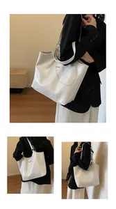 Detail of white glossy patent leather tote bag with large capacity and thin shoulder straps