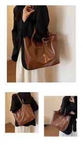 Detail view of large brown faux leather tote bag with glossy finish and metal hardware