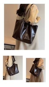 Macro shot of dark brown large tote bag with oil wax leather texture and golden hardware