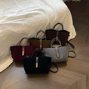 Frosted suede tote bags in various colors with gold oval buckles and crossbody straps
