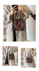 Détail du sac seau à imprimé léopard avec finitions en cuir et boucle dorée