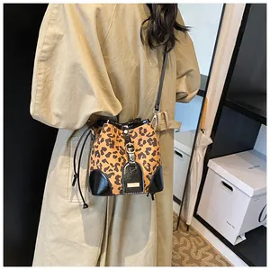 Tragebild der Bucket Bag mit Leopardenmuster, schwarzen Lederdetails und Standfüßen