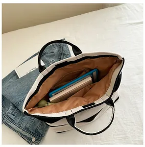 Detail of the large capacity tote bag interior with zip pocket and black white stripes