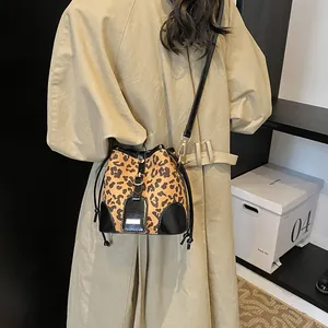 Modische Leopard-Beuteltasche mit schwarzem Lederbesatz und Gold-Schnalle am Model getragen