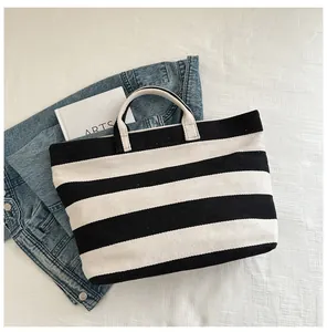 Detailed top view of large canvas tote bag featuring classic black and white horizontal stripes