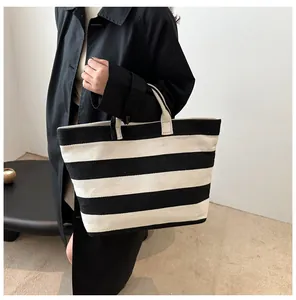 Detailed view of the large capacity black and white striped tote bag on model