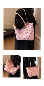 Dettaglio della borsa tote rosa con stampa a ciliegie e lunghe tracolle sottili